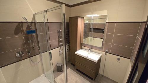 a bathroom with a glass shower and a sink at First Line - Dzintaru prospekts Apartment in Jūrmala