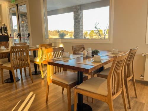 a dining room with a wooden table and chairs at Hotel Finca Alvear in General Alvear