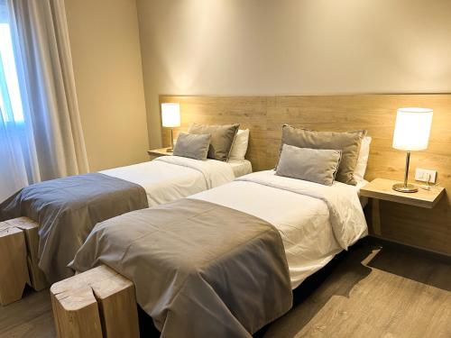 a hotel room with two beds and a window at Hotel Finca Alvear in General Alvear