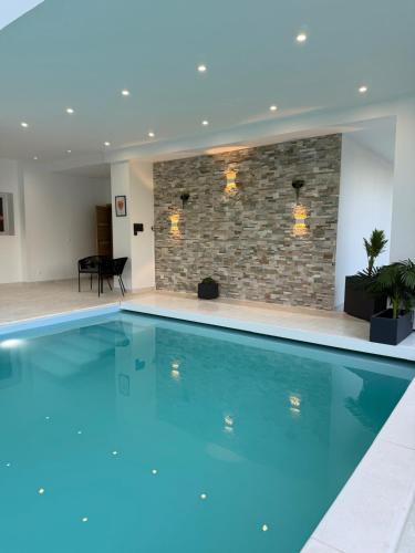 a large swimming pool in a building with a brick wall at EXCEPTIONNEL Studio VERSAILLES in Le Chesnay