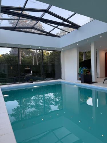 a swimming pool in a house with a glass ceiling at EXCEPTIONNEL Studio VERSAILLES in Le Chesnay