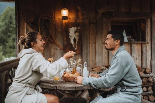 a man and a woman sitting at a table at Chalet trappeur in Le Biot
