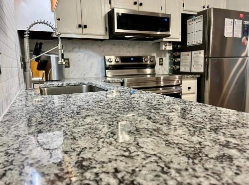 a kitchen with a granite counter top with a sink at 2 Bedroom Oceanview Condo at Sea Cabin! Sleeps 5! in Myrtle Beach