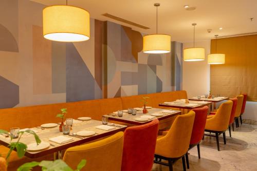 a dining room with tables and chairs and lights at Radisson Blu Kochi in Cochin