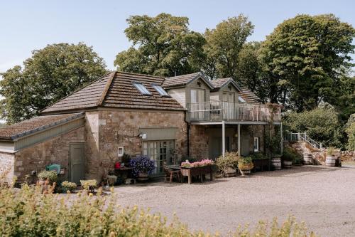 an old stone house with a balcony on top of it at The Keep in Kirknewton