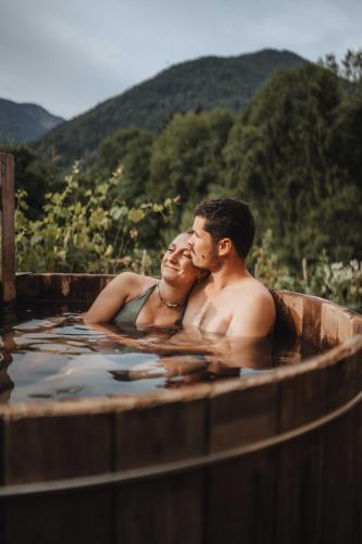a man and a woman sitting in a hot tub at Chalet trappeur in Le Biot