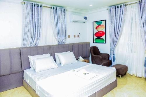 a bedroom with a bed and a couch and a chair at Luxury BDR Wi-Fi Games in Abuja
