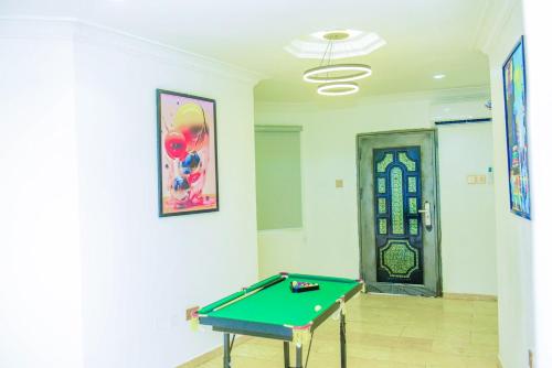 a room with a pool table in front of a door at Luxury BDR Wi-Fi Games in Abuja