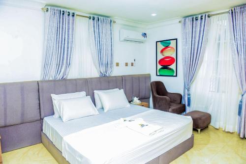 a bedroom with a bed and a couch and a chair at Luxury BDR Wi-Fi Games in Abuja
