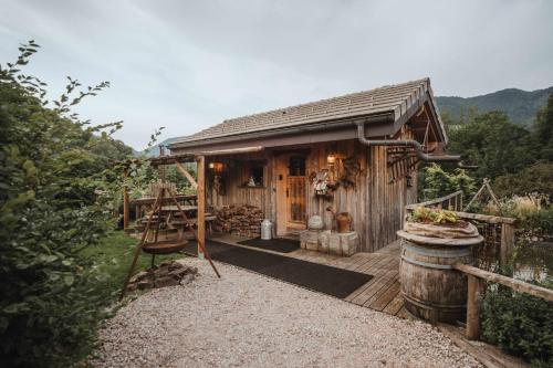a wooden cabin with a deck and a barrel at Chalet trappeur in Le Biot