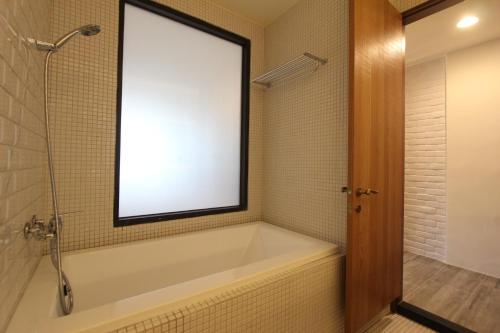 a bathroom with a bath tub with a large window at Muguang Inn in Hengchun