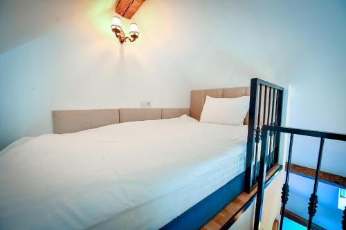 a bedroom with a bed with white sheets at Casa Baritiu M in Braşov