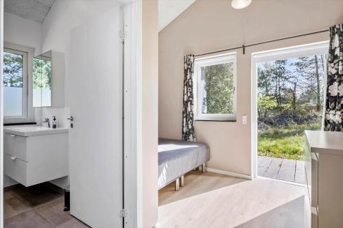 baño con cama, lavabo y ventana en BL1266-Pandrup-Rodhusparken-58, en Pandrup