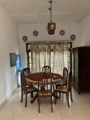 a dining room with a table and chairs at Ameeila villa in Kandy