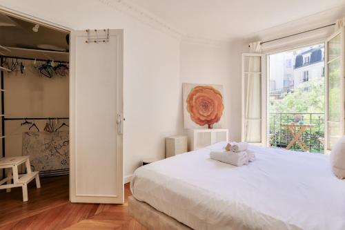 une chambre blanche avec un grand lit et une fenêtre dans l'établissement Lovely 2BR Flat with balcony - Eiffel Tower & Seine, à Paris