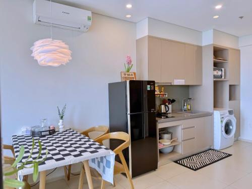 a kitchen with a table and a black refrigerator at Gạo's Homestay - The Song in Vung Tau