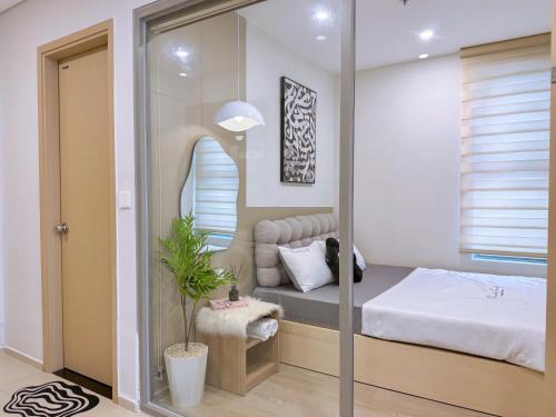 a small bedroom with a bed and a mirror at Gạo's Homestay - The Song in Vung Tau