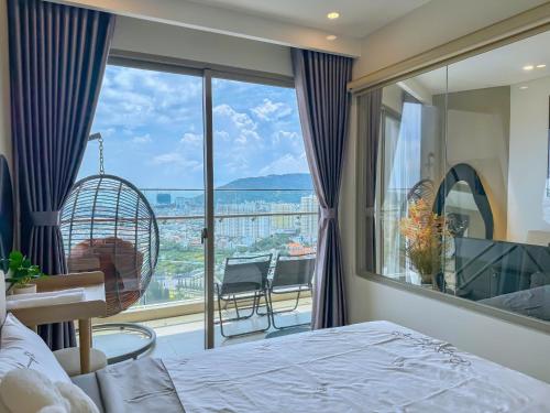 a bedroom with a bed and a large window at Gạo's Homestay - The Song in Vung Tau