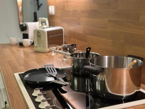 a stove with pots and pans on top of it at Mileticova street, keyless, AC in Nivy