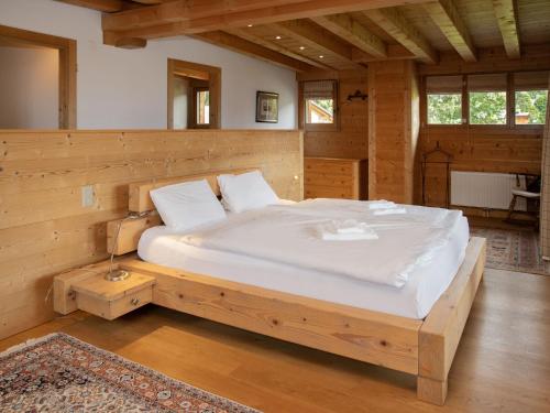 a bedroom with a wooden bed in a room at Chalet Khamariah by Interhome in Villars-sur-Ollon
