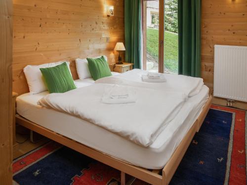 a large white bed in a room with a window at Chalet Khamariah by Interhome in Villars-sur-Ollon