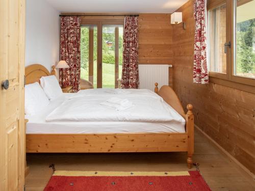 a wooden bed in a room with a window at Chalet Khamariah by Interhome in Villars-sur-Ollon