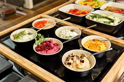 a buffet with bowls of different types of food at Austria Trend Hotel Congress Innsbruck in Innsbruck