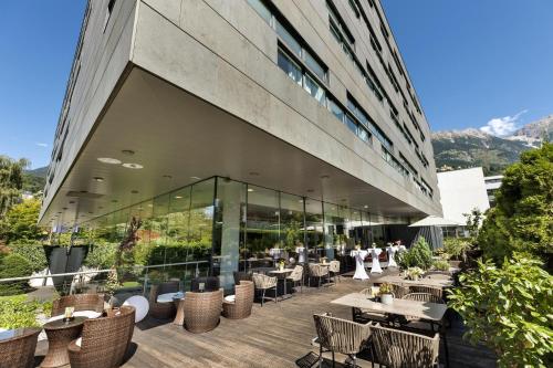 a restaurant with tables and chairs and a building at Austria Trend Hotel Congress Innsbruck in Innsbruck