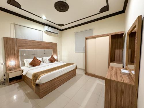 a bedroom with a large bed in a room at Masaf apartment in Al Mithnab