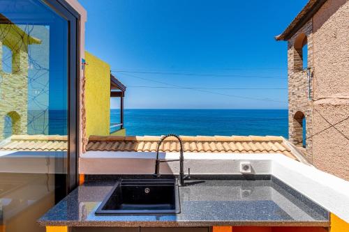 a kitchen sink with a view of the ocean at Yellow Wave in Paul do Mar