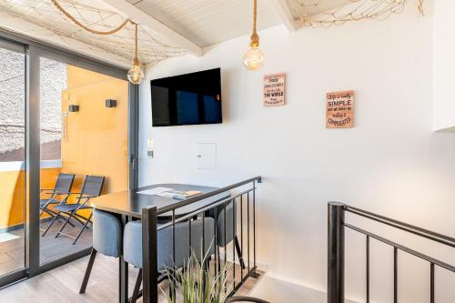 a dining room with a table and chairs on a balcony at Yellow Wave in Paul do Mar