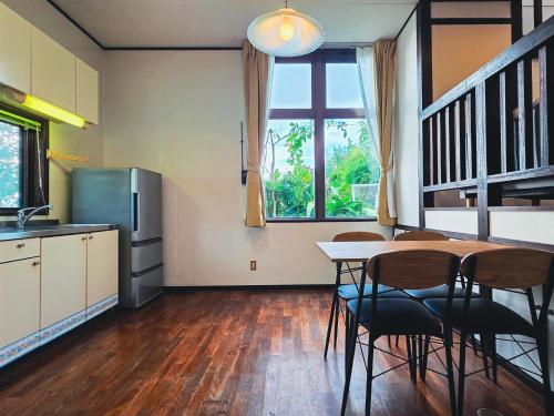 a kitchen and dining room with a table and chairs at LOGIN OKINAWA -mayonaka- in Onna