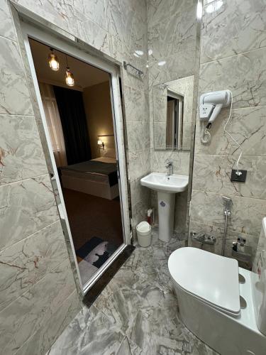 a bathroom with a sink and a toilet and a mirror at Resort Hotel Baku in Baku