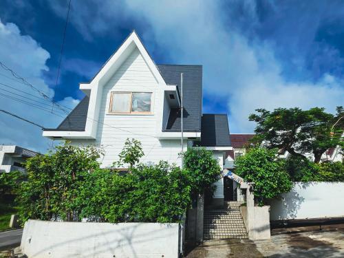 a white house with a fence in front of it at LOGIN OKINAWA -mayonaka- in Onna