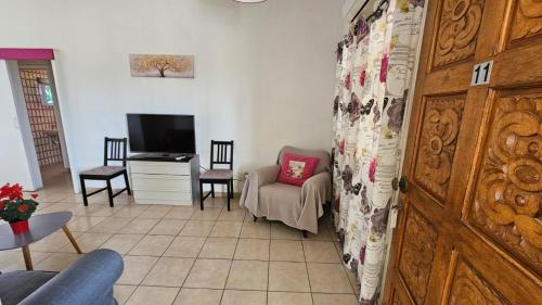 a living room with a chair and a television at Magic Sea Apartments in Larnaka