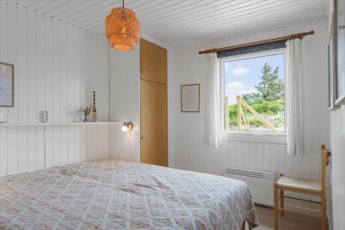 a white bedroom with a bed and a window at BL1020-Pandrup-Hunetorp-Klitvej-257 in Pandrup