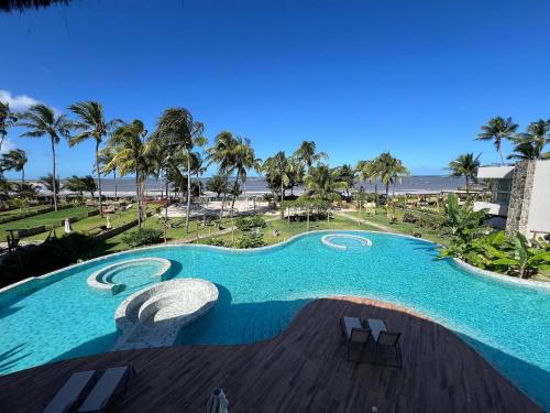 a large swimming pool with a view of the beach at Bangalô moderno e super bem equipado in Passo de Camarajibe