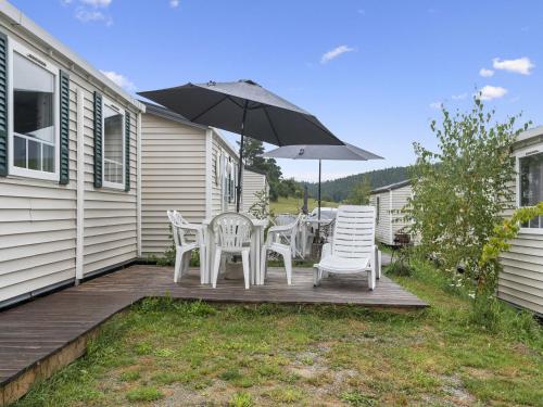 a wooden deck with chairs and an umbrella at Holiday Home Prima Plus by Interhome in Koloděje nad Lužnicí
