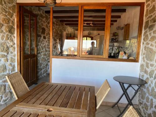 a wooden table and chairs in front of a kitchen at Casa Padume - Maison de village en Balagne in Nessa