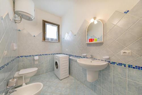 a bathroom with a sink and a toilet and a mirror at Residenza Le Farfalle in Tergu