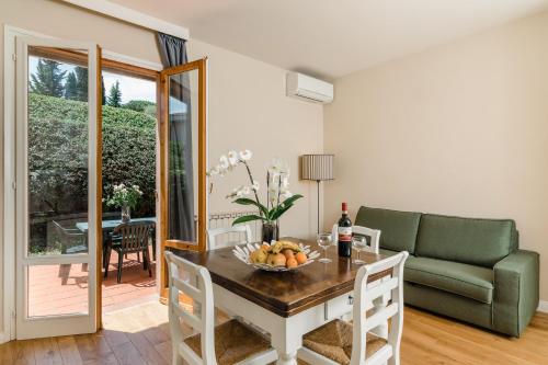 a living room with a table and a green couch at Residence Poggio Golf Chianti Firenze in Impruneta