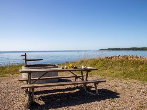 a picnic table with a grill next to the water at Holiday Home Särdals Lycke by Interhome in Steninge