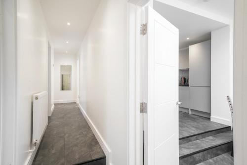 a hallway with white walls and a staircase at Modern Flat near Wembley stadium in The Hyde