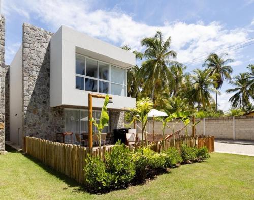 a house with a fence in front of it at Bangalô moderno e super bem equipado in Passo de Camarajibe
