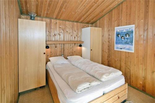 a bed in a room with a wooden wall at BL363-Saltum-Nyborgvej-4 in Saltum