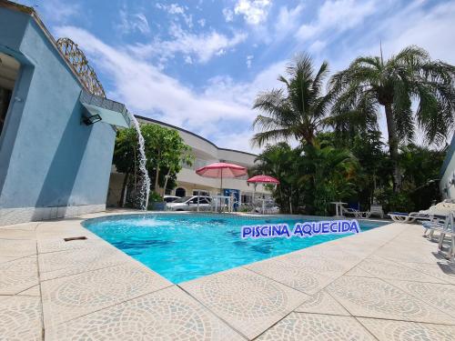 a swimming pool in front of a building at Hotel Pousada Iracemar - Piscina Aquecida in Guarujá