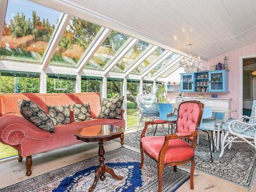 a conservatory with a couch and chairs and a table at 4 person holiday home in Thisted in Thisted