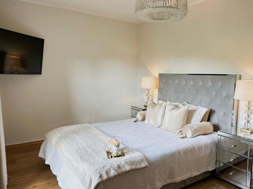 a bedroom with a large white bed with a television at Apartment Am Obersalzberg by Interhome in Berchtesgaden