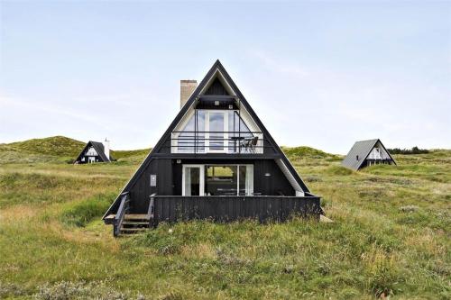 a black triangular house in a field with windows at BL1193-Pandrup-Narhvalen-14 in Pandrup