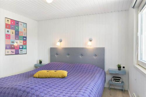 a bedroom with a purple bed with a yellow pillow on it at BL1729-Blokhus-Jens-Baerentsvej-36 in Blokhus
